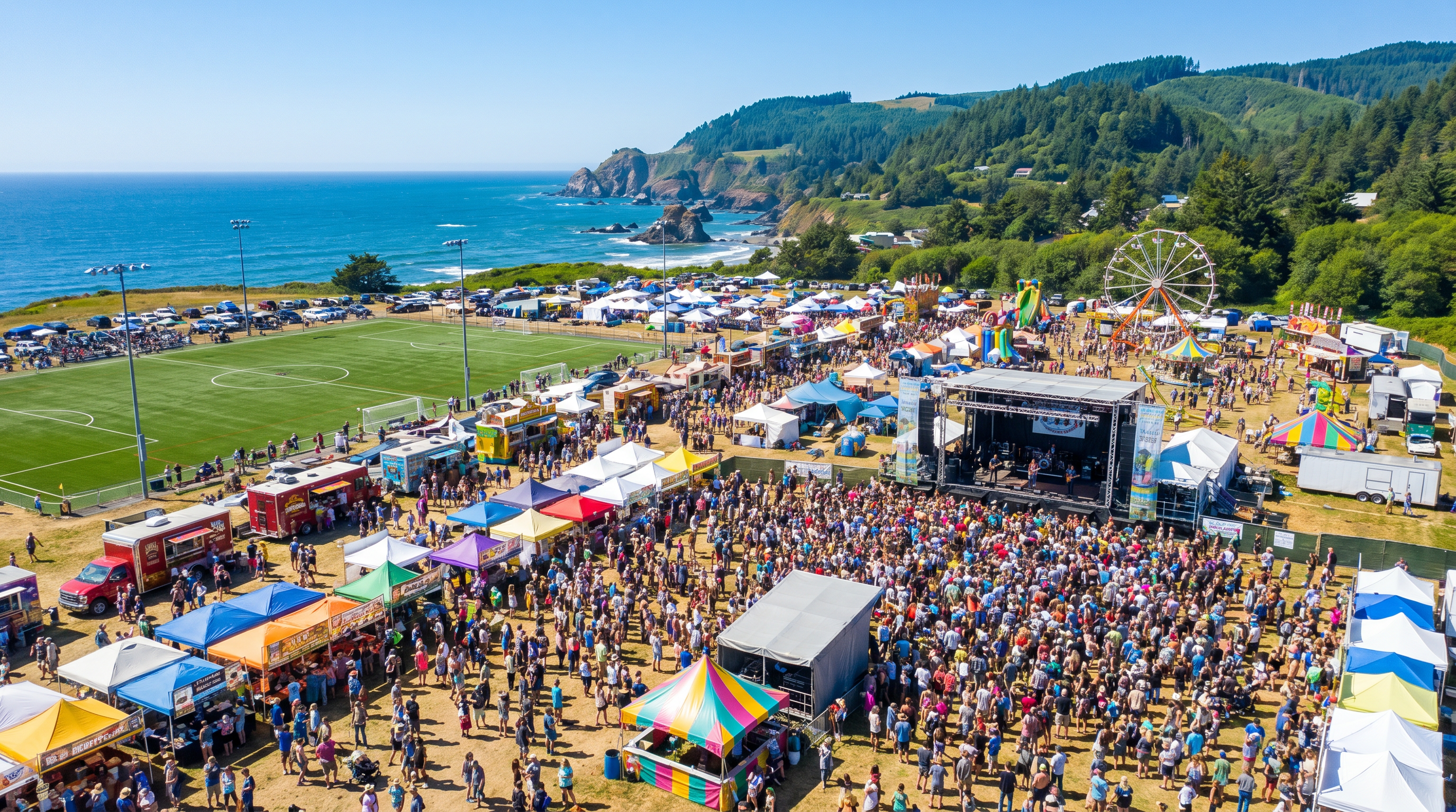 Aerial view of an Oregon Coast outdoor festival with sports fields, live stage, food trucks, and a large crowd